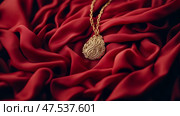 Ornamental treasure: A golden pendant nestles on luxurious folds of scarlet fabric, radiating elegance and subtle opulence. Стоковое AI-изображение, AI-художник Данила Большаков / Фотобанк Лори