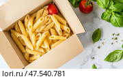 Delicious uncooked penne pasta with fresh basil and tomatoes in a takeout box on a marble countertop. Стоковое AI-изображение, AI-художник Сергей Толмачёв / Фотобанк Лори