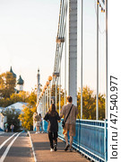 The bridge over the Kotorosl River to Damansky Island and people passing by. Yaroslavl, Russia. Редакционное фото, фотограф Photojuli / Фотобанк Лори