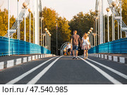 The bridge over the Kotorosl River to Damansky Island and people passing by. Yaroslavl, Russia. Редакционное фото, фотограф Photojuli / Фотобанк Лори
