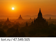 Sunset Over Ancient Temples in Bagan Highlights Silhouettes Against a Golden Sky. Стоковое AI-изображение, AI-художник Юлия Гапеенко / Фотобанк Лори