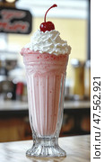 Delicious strawberry milkshake topped with whipped cream and cherry in a classic diner. Стоковое AI-изображение, AI-художник Юрий Поздников / Фотобанк Лори