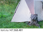 Installed tourist tent And backpack in a camping in nature in the forest. Domestic tourism, active summer holidays, family adventures. Ecotourism, sport, hike. Copy space, mock up. Стоковое фото, фотограф Ольга Симонова / Фотобанк Лори