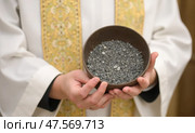 Priest Holds a Bowl of Ashes During Ash Wednesday Observance in a Serene Church Setting. Стоковое AI-изображение, AI-художник Sergey Grishin / Фотобанк Лори