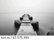 Calm pier extends into misty waters during serene twilight hour. Спокойный пирс переходит в туманные воды во время безмятежного сумеречного часа. Стоковое AI-изображение, AI-художник Katsiaryna Repich / Фотобанк Лори