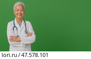 Confident senior doctor posing with stethoscope against green backdrop. Стоковое AI-видео, аниматор Владимир Федоров / Фотобанк Лори