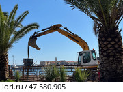 Budva,Montenegro-April 11,2025:A Liebherr excavator working by the sea. Редакционное фото, фотограф Margarita Davchenko / Фотобанк Лори