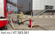 ANGARSK, IRKUTSK REGION, RUSSIA - April 08, 2025: Video of group of firefighters enters building to put out fire. Fire hose is connected to street hydrant. Firefighters preventive training. Редакционное видео, видеограф Виктория Катьянова / Фотобанк Лори