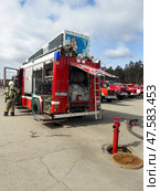 ANGARSK, IRKUTSK REGION, RUSSIA - April 08, 2025: Firefighters connect fire hose to street hydrant to extinguish fire. Red fire trucks lined up on square. Preventive training of firefighters. EMERCOM. Редакционное фото, фотограф Виктория Катьянова / Фотобанк Лори