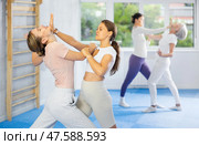 Woman and girl in gym perform basic elements of krav maga self-defense system. Стоковое фото, фотограф Яков Филимонов / Фотобанк Лори