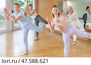 Women dancing synchronous group choreography in dance hall. Стоковое фото, фотограф Яков Филимонов / Фотобанк Лори