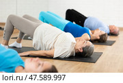 Senior woman doing inverted back-bending asana in fitness studio. Стоковое фото, фотограф Яков Филимонов / Фотобанк Лори