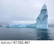 A huge high breakaway glacier drifts in the southern ocean off the coast of Antarctica at sunset, the Antarctic Peninsula, the Southern Arctic Circle, azure water, cloudy weather. Стоковое фото, фотограф Vladimir Drozdin / Фотобанк Лори
