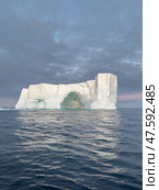 A huge high breakaway glacier drifts in the southern ocean off the coast of Antarctica at sunset, the Antarctic Peninsula, the Southern Arctic Circle, azure water, cloudy weather. Стоковое фото, фотограф Vladimir Drozdin / Фотобанк Лори