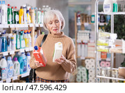 Mature woman choosing unclogging agent in department store. Стоковое фото, фотограф Яков Филимонов / Фотобанк Лори