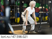 Senior woman performing deadlifts with barbell at gym. Стоковое фото, фотограф Яков Филимонов / Фотобанк Лори