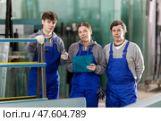 Girl and two male glazier employees with documents speaking and advising in workshop. Стоковое фото, фотограф Яков Филимонов / Фотобанк Лори
