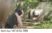 Closeup of woman fires a rifle at shooting range target outside on summer day. Стоковое видео, видеограф Дмитрий Нечаев / Фотобанк Лори