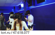 Portrait of happy excited young woman with VR glasses on head, holding handheld controllers playing virtual reality game with friends. Стоковое видео, видеограф Яков Филимонов / Фотобанк Лори