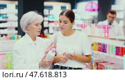 Senior woman pharmacist helps girl buyer to decide on choice of gel for intimate hygiene. Стоковое видео, видеограф Яков Филимонов / Фотобанк Лори