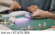 Interactive experiment with epoxy resin as child explores curing process under UV lamp. Parent supervises, ensuring fun and educational experience in safe home environment. Стоковое видео, видеограф Енваев Андрей / Фотобанк Лори