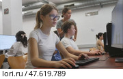 Interested young female student with glasses working on computer in library, looking for necessary information on Internet. Стоковое видео, видеограф Яков Филимонов / Фотобанк Лори