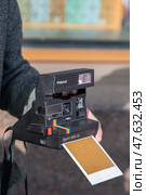 Камера Polaroid Spirit 600 CL крупным планом в руках. Съёмка с мгновенной проявкой и печатью. Редакционное фото, фотограф Олег Амфитеатров / Фотобанк Лори