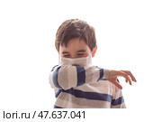 A boy with closed eyes sneezes or coughs into his elbow on white background. Стоковое фото, фотограф Zakharova Natasha / Фотобанк Лори