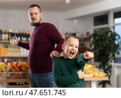 Disgruntled boy asks dad to buy at grocery store. Стоковое фото, фотограф Яков Филимонов / Фотобанк Лори