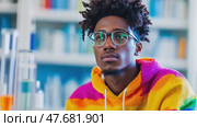 Scientist researcher in a lab setting, wearing a colorful hoodie and glasses, looking thoughtful and pensive. Стоковое AI-видео, аниматор Данила Большаков / Фотобанк Лори