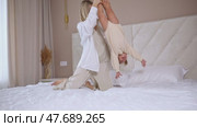 Attractive young woman and little cute girl are spending time together in bedroom at home. Smiling mom holding her excited small girl child upside down. Happy family concept. Mother's day footage. Стоковое видео, видеограф Ирина Михайличенко / Фотобанк Лори
