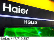 Современный телевизор Haier HQLED с плоским экраном продается в магазине электроники. Стоковое фото, фотограф FotograFF / Фотобанк Лори
