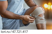 Man applying knee brace at home. Стоковое AI-видео, аниматор Юрий Поздников / Фотобанк Лори