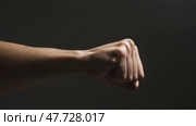 Fist showing determination against a dark background. Стоковое AI-видео, аниматор KATERINA AI / Фотобанк Лори