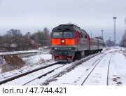Магистральный тепловоз ТЭП70-0121 с пригородным поездом отправляется со станции Осташков, Тверская область (2021 год). Редакционное фото, фотограф Алексей Иванов / Фотобанк Лори