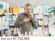 Senior man visits pharmacy and suffers from cough. Стоковое фото, фотограф Яков Филимонов / Фотобанк Лори