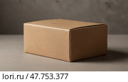 Simple brown cardboard box sitting on a gray surface in a well-lit room. Стоковое AI-изображение, AI-художник Сергей Толмачёв / Фотобанк Лори