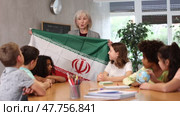 in entertaining geography lesson, children look at flag of Iran with interest. Стоковое видео, видеограф Яков Филимонов / Фотобанк Лори