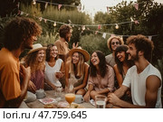 Young happy friends gathered together to spend summer evening enjoying pleasant conversation, delicious food in backyard outdoors. They laugh and joke merrily, forgetting about all the problems and worries. Стоковое AI-изображение, AI-художник Данила Большаков / Фотобанк Лори