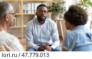 A therapist listens intently in a counseling session with a couple seeking guidance, seated in a cozy, sunlit room. Стоковое AI-изображение, AI-художник Данила Большаков / Фотобанк Лори