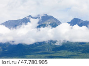 Natural background of mountain peaks in low cumulus clouds in summer day. Scenic mountains landscape. Siberia. Baikal region. Eastern Sayan Mountains. Buryatia. Tunka foothill valley. Arshan. Стоковое фото, фотограф Виктория Катьянова / Фотобанк Лори