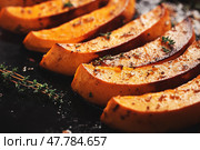 Cutting Fresh Pumpkins on Board. Baked pumpkin. Sliced Cucurbita maxima and spices for preparing soup, warm salad, fall dish. Thanksgiving food. Roasted vegetable in olive oil salt pepper, herbs. Стоковое AI-изображение, AI-художник Марина Демидюк / Фотобанк Лори