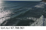 Gentle waves cascading over sandy beach, sunlight sparkling on rippling water surface, creating peaceful coastal scenery. Стоковое видео, видеограф ILIA GOROKHOV / Фотобанк Лори