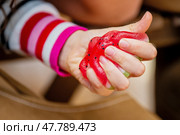A child's hand squeezes a bright anti-stress toy Taba Paw in the shape of a watermelon. Стоковое фото, фотограф Мария Мороз / Фотобанк Лори