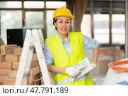 Portrait of a positive woman builder standing near a stepladder. Стоковое фото, фотограф Яков Филимонов / Фотобанк Лори