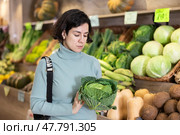 Shopping for vegetables in a supermarket - man selects cabbage. Стоковое фото, фотограф Яков Филимонов / Фотобанк Лори