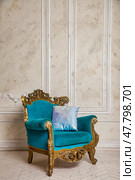 Elegant Turquoise Chair With Ornate Golden Details in a Refined Indoor Setting. Стоковое фото, фотограф Aleksandr Golubev / Фотобанк Лори