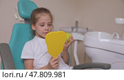 Little girl are eating green apple in the dentist's chair and looking in the mirror at her teeth. Healthy teeth concept. Child eat a green apple. Slow motion footage. Стоковое видео, видеограф Ирина Михайличенко / Фотобанк Лори
