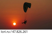 Motor paraglider flying through colorful sunset sky. Стоковое фото, фотограф Михаил Коханчиков / Фотобанк Лори