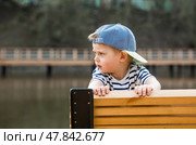 Summer lifestyle. A cute little boy is having fun playing in a modern outdoor playground. The concept of family entertainment and leisure. Стоковое фото, фотограф Photojuli / Фотобанк Лори